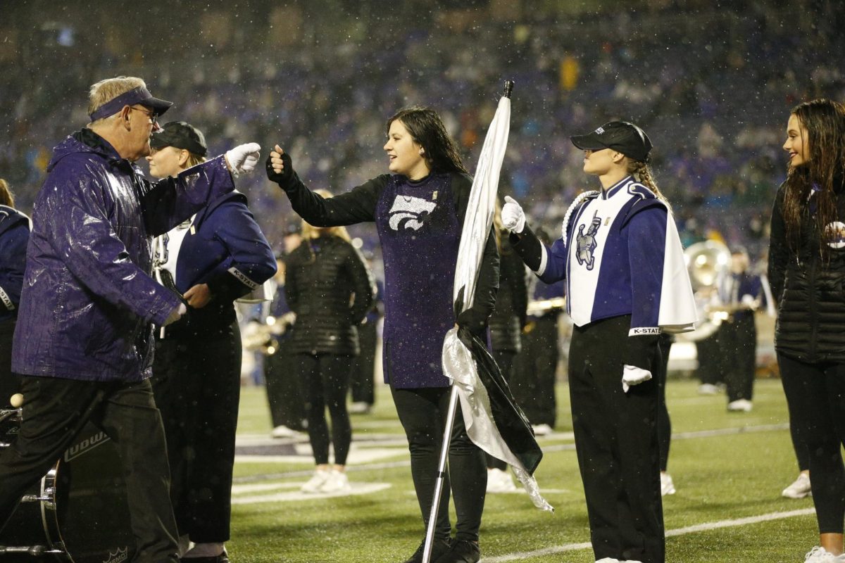 Fist bumping, a color guard senior is congratulated by band director Dr. Frank Tracz on her accomplishments while celebrating senior night in fall 2022. Photo by Macey Franko.