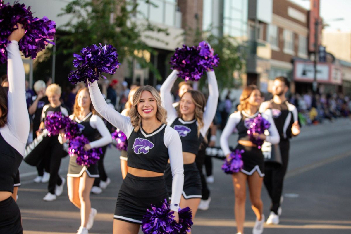 The KSU cheerleaders walk through Aggieville during the 2024 Homecoming parade. Photo by Emily Lenk.